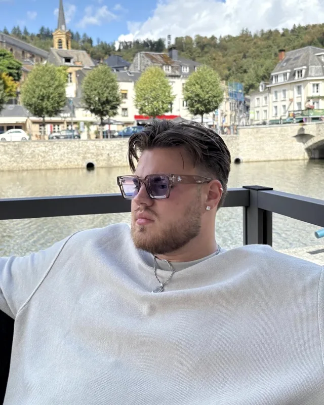 Gianni Adam met zonnebril aan het water in een stadje